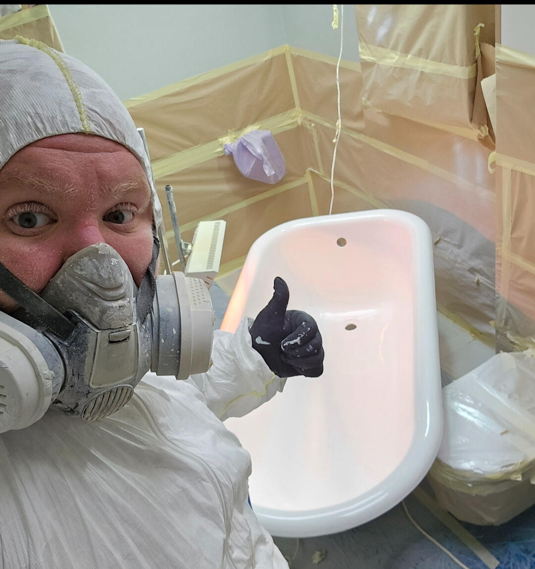 photo of glossy baths owner photo of glossy baths re-enamelling owner Seamus with a thumbs up, in ppe, in a room full of masking up and a completed bath in Southampton